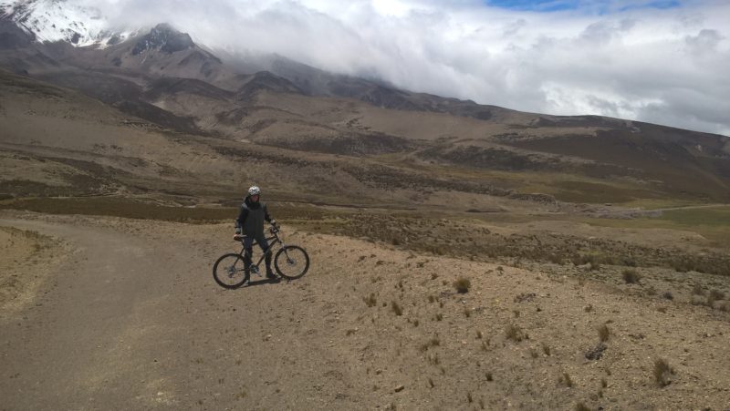 Corentin à côté de son vélo devant le volcan